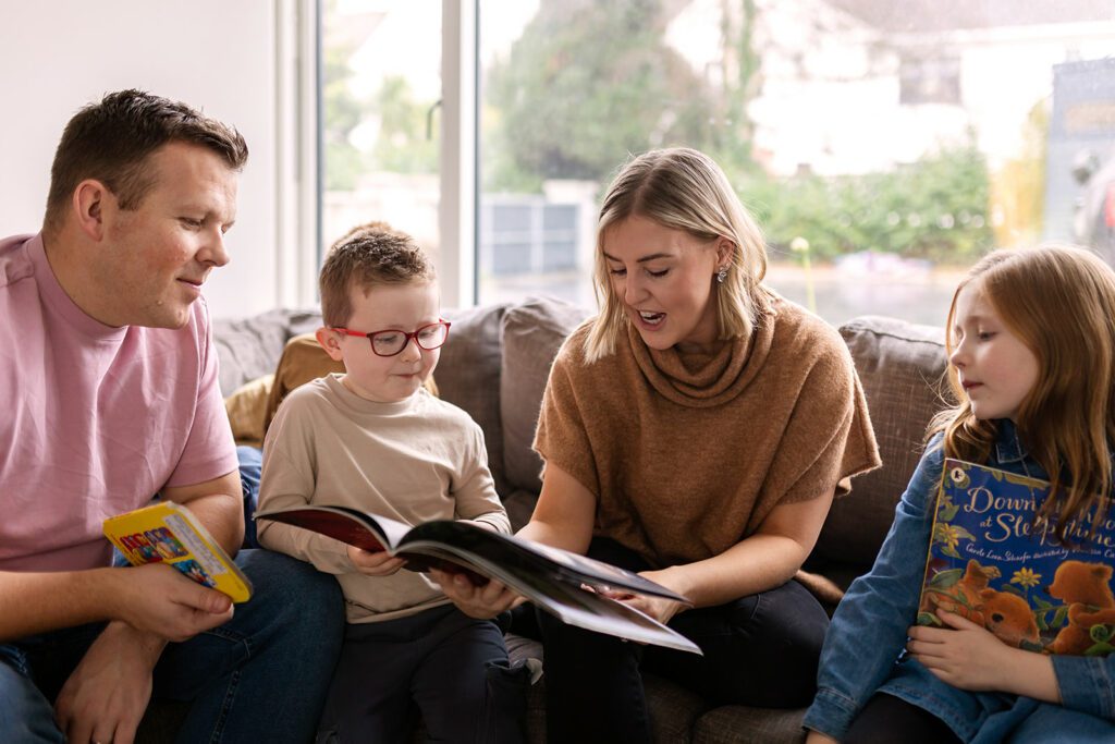 Family reading a storybook together on the sofa at home