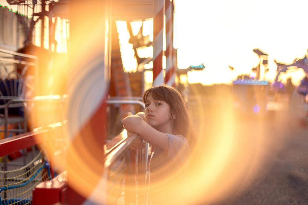 little girl at the fun fair at golden hour