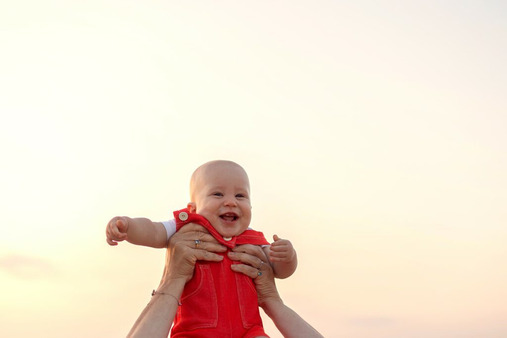 baby playing with his mom at the beach