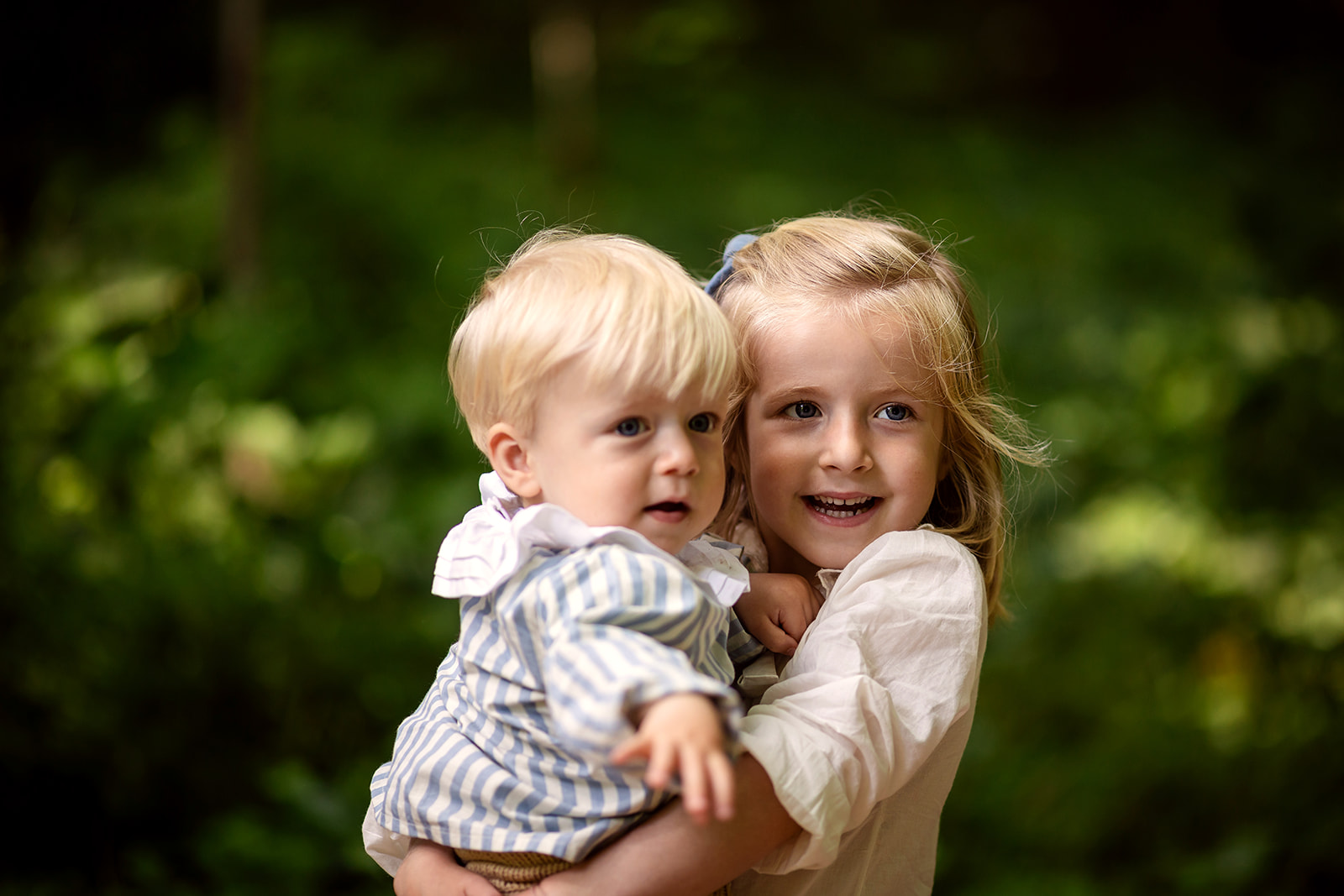 little girl holding baby brother