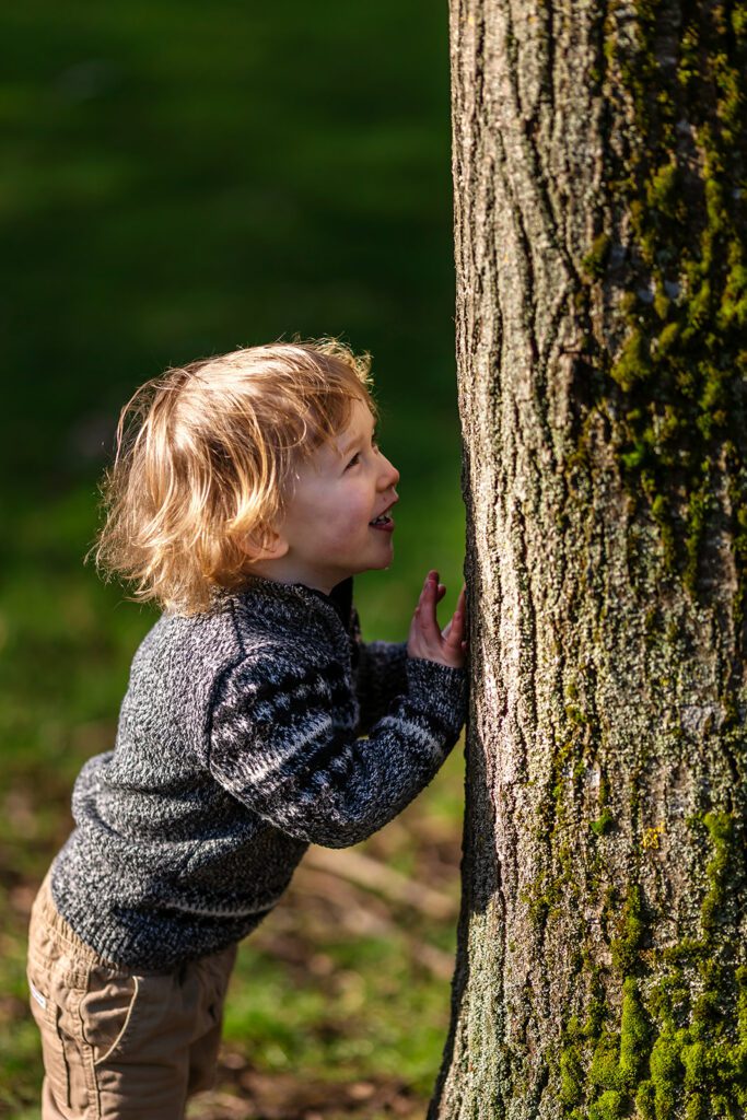 toddler boy playing hide and seek for Family photography in Memorial Garden Dublin