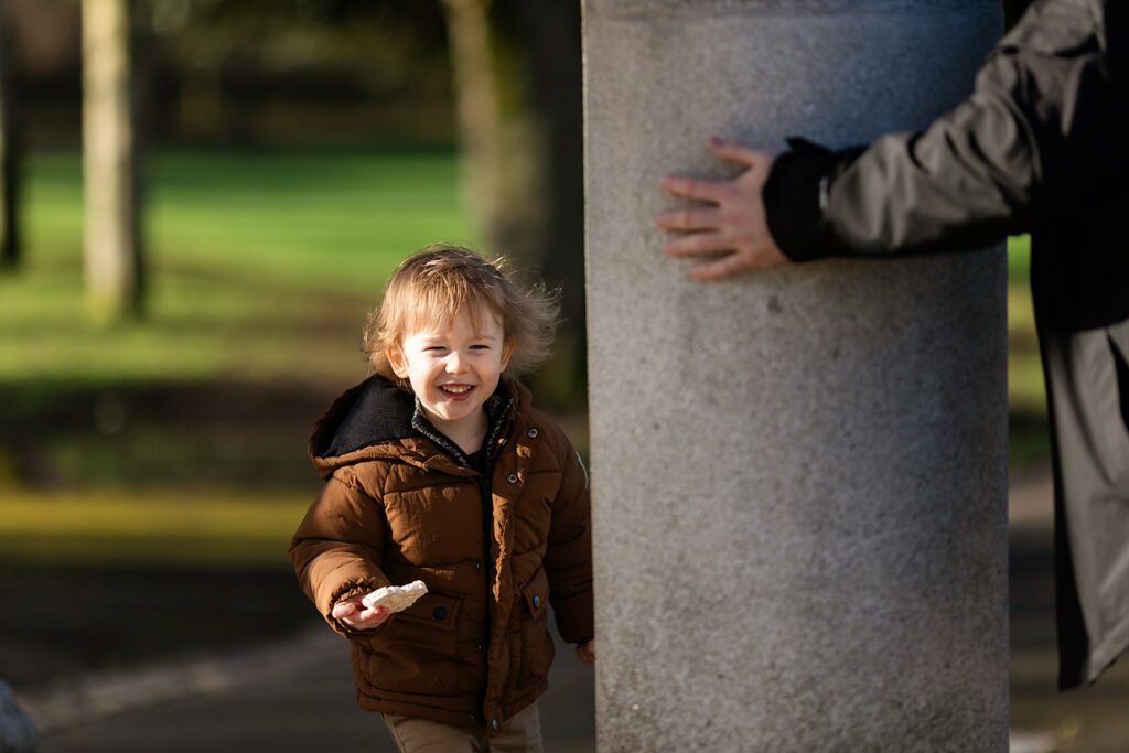 toddler boy playing hide and seek with dad for a winter photoshoot in Dublin