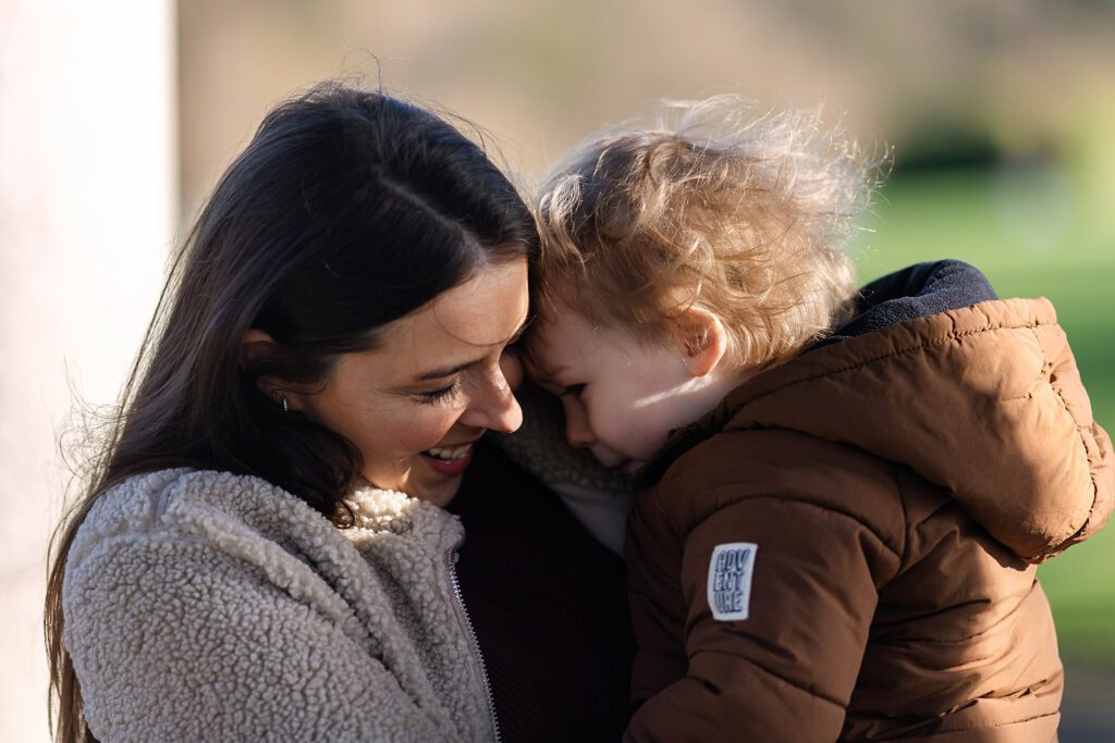 mother holding toddler and smiling at memorial garden Dublin