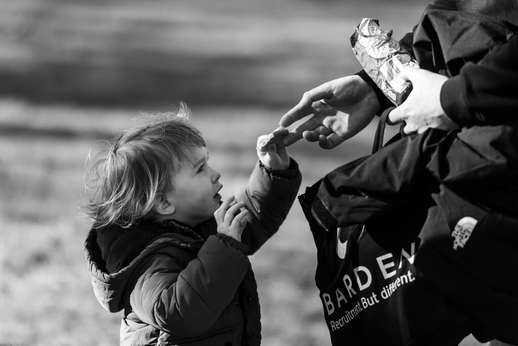 father feeding son a snack at the park