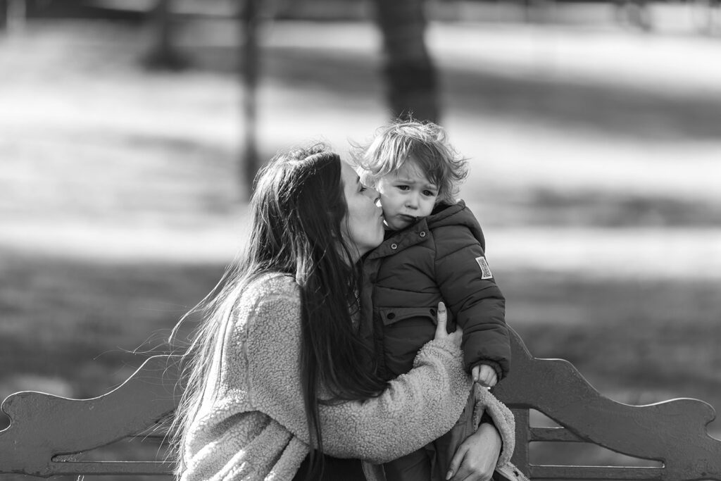 mother kissing toddler son on the cheek