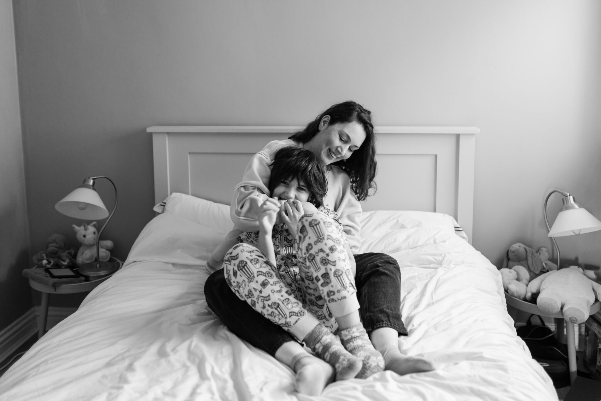 Aurélie Lenoir sitting on a bed with her son at home