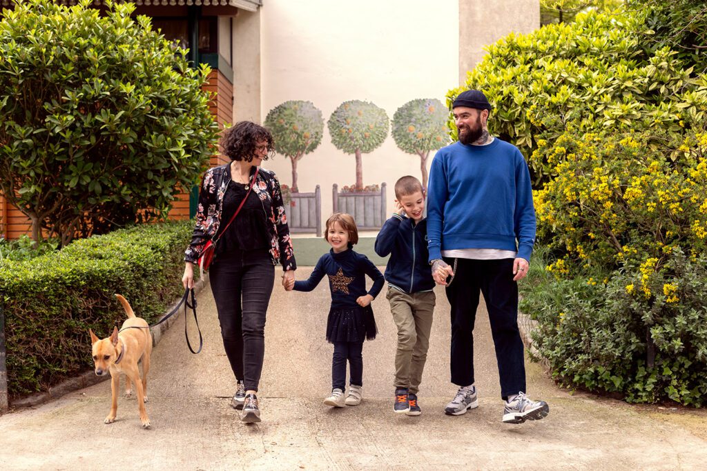family walking at the park with their kids and dog