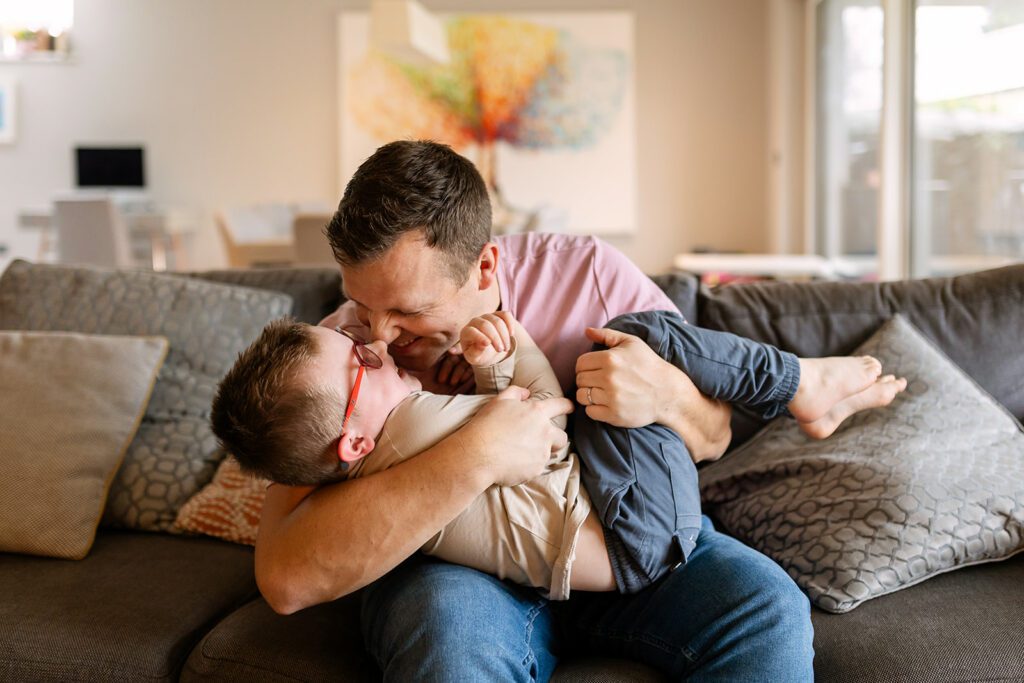 father and son cuddling on the couch