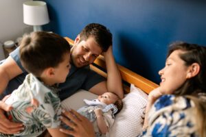How to get comfortable during a family photo shoot, family laughing on the bed at home