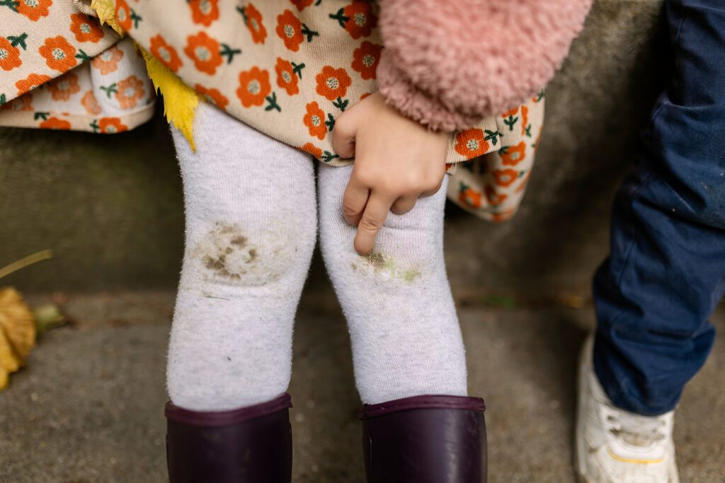 detail of little girl wearing rain boots in autumn