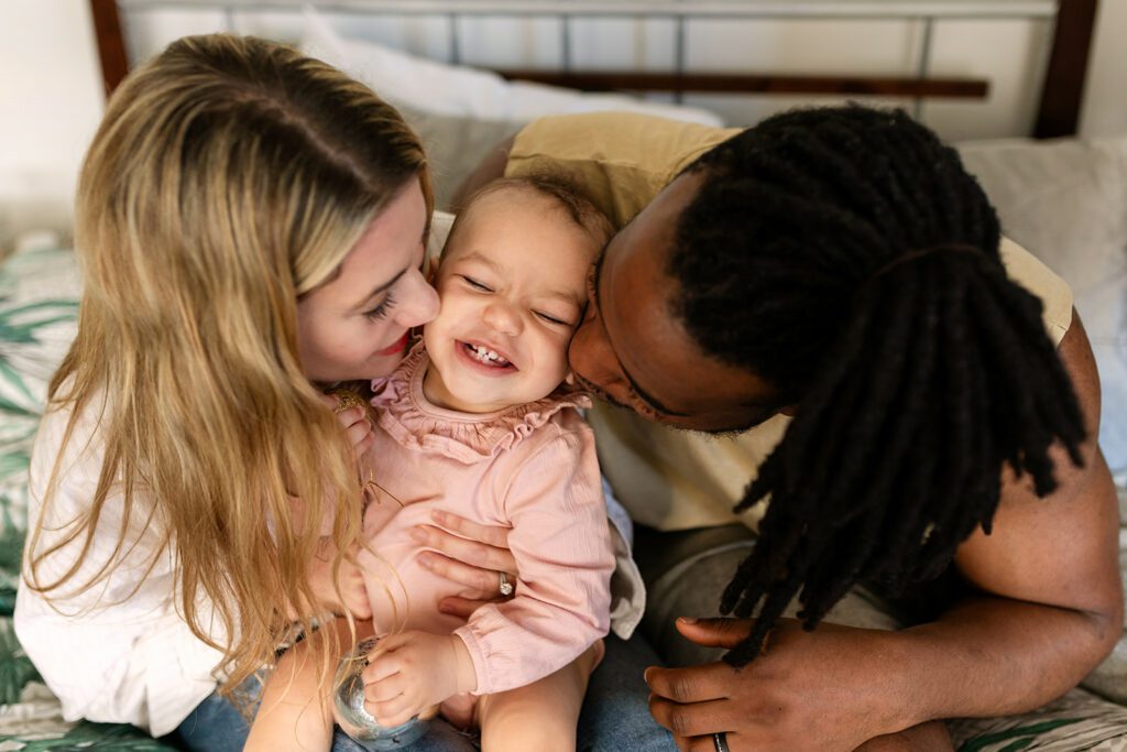 mum and dad kissing their toddler girl on the cheek for Natural Family Portraits
