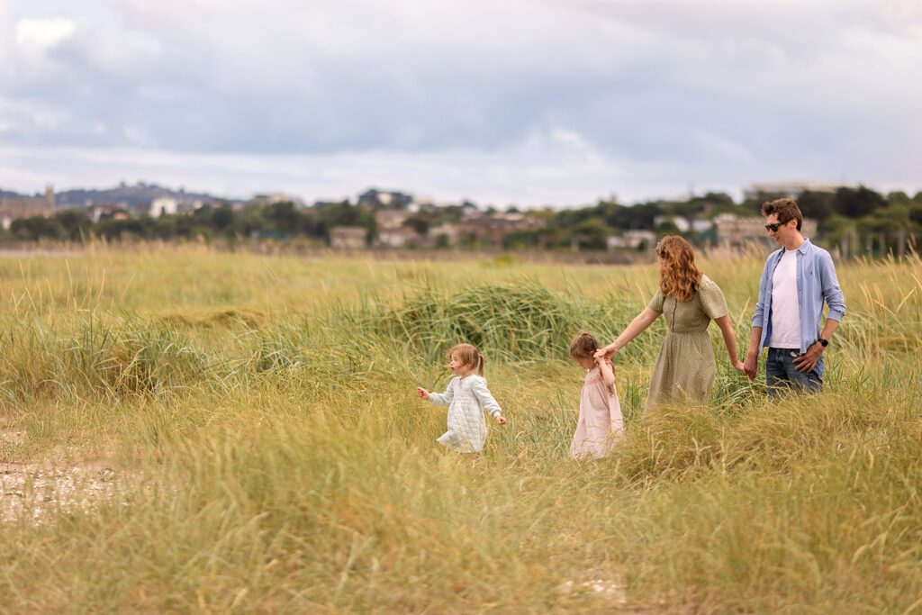 family photographed playing on the sandymount beach in Dublin