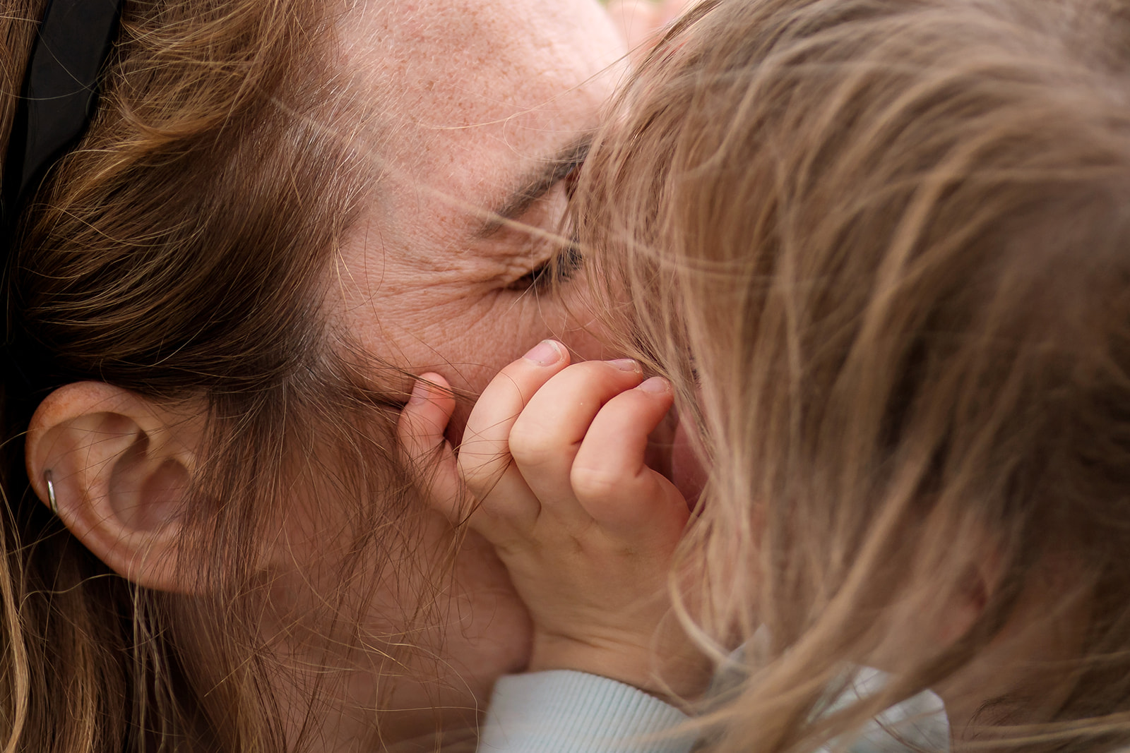 mum and kid kissing and cuddling