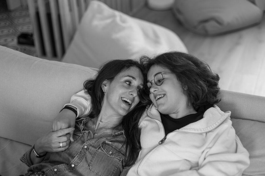 mum laughing and relaxing at home with her teenage girl