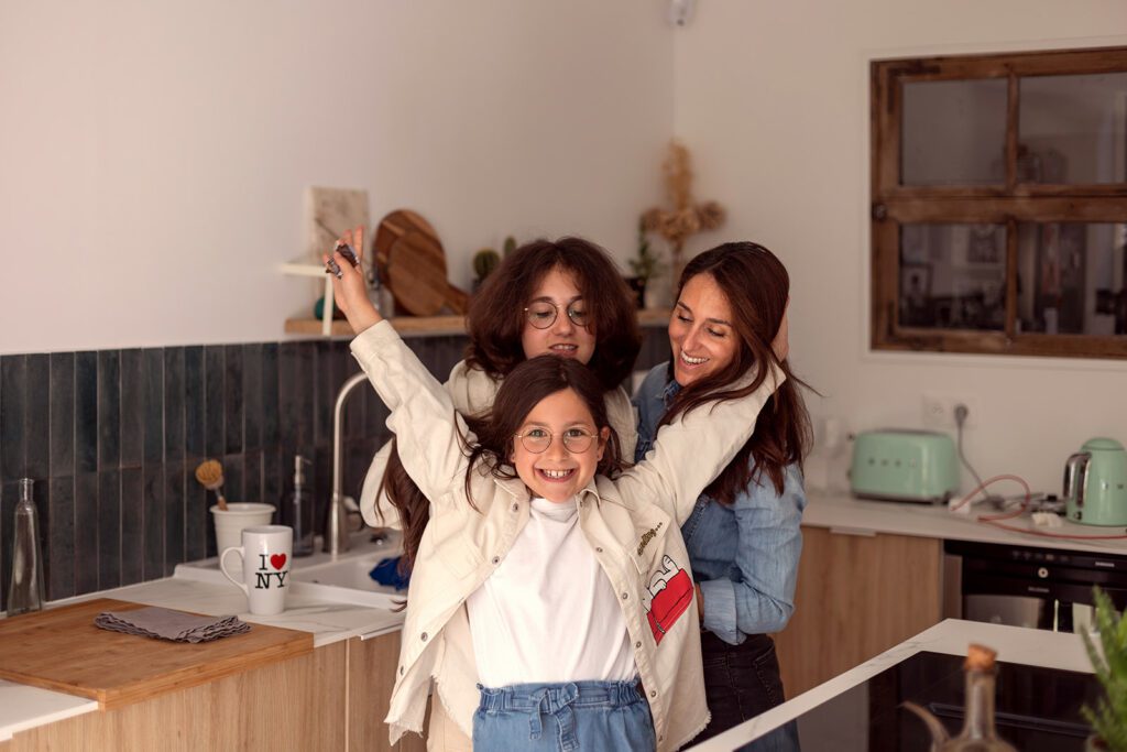 mum having a relaxed moment with her daughters in the family kitchen