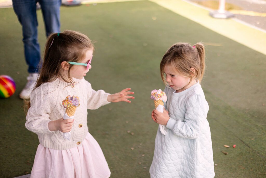 Unposed family photo of 2 siblings having ice cream