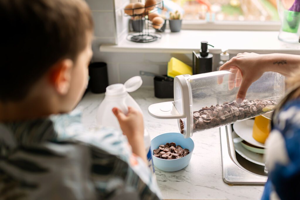 Unposed family photo of a mom and child making cereal