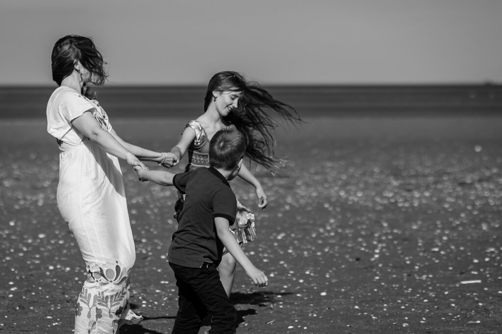 family playing on the beach and posing for a Vacation photographer in Dublin