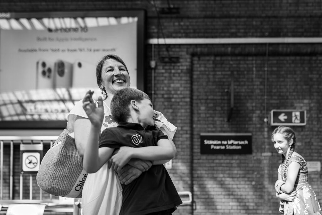 mother and son playing and laughing at the train station