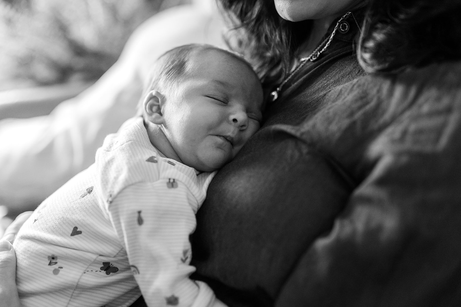 newborn sleeping in his mom's arms