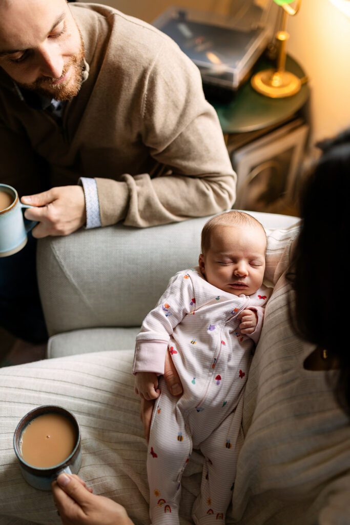 father and mother cuddling their newborn a home
