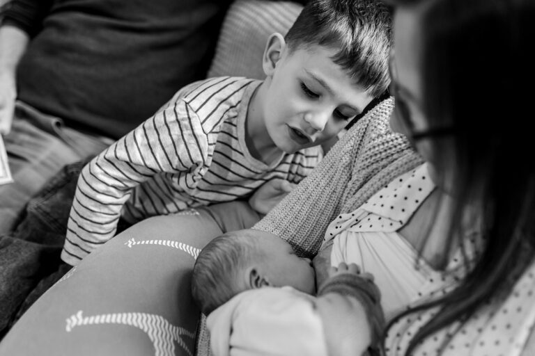 little boy gazing at his newborn sibling