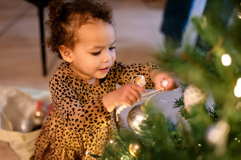 toddler decorating the christmas tree at home