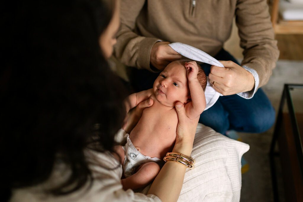 mother and father taking care of their newborn at home