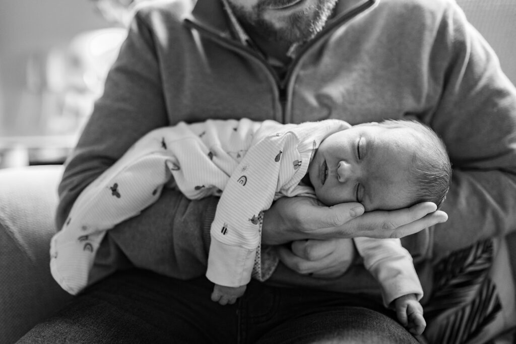 father holding his newborn in a cute pose