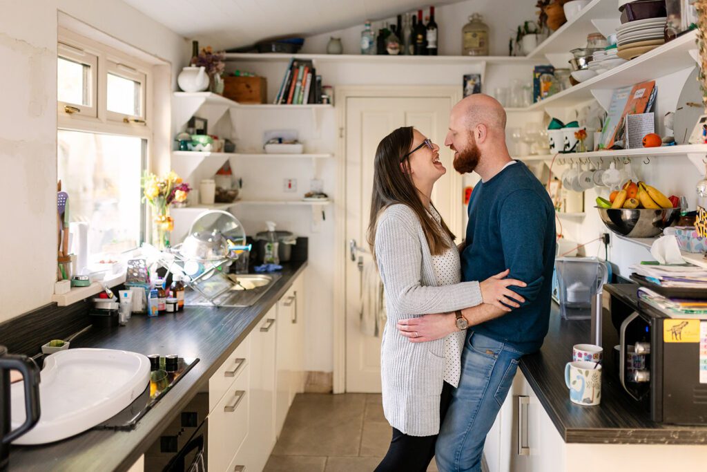 parents laughing and hugging in their kitchen
