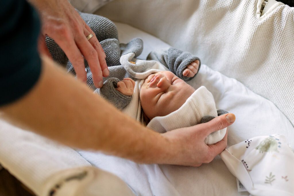 father comforting his newborn baby at home for natural newborn photography Dublin