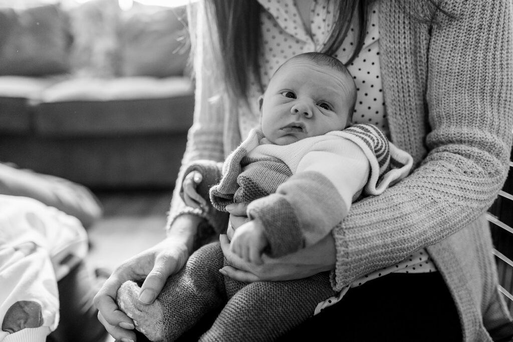 mom holding newborn baby at home