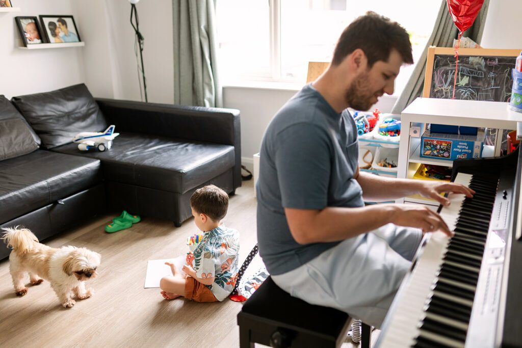 father playing piano, small and messy home family photos Dublin