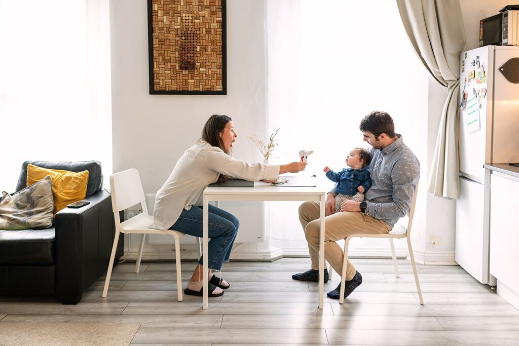 mother and father giving their baby girl lunch at home