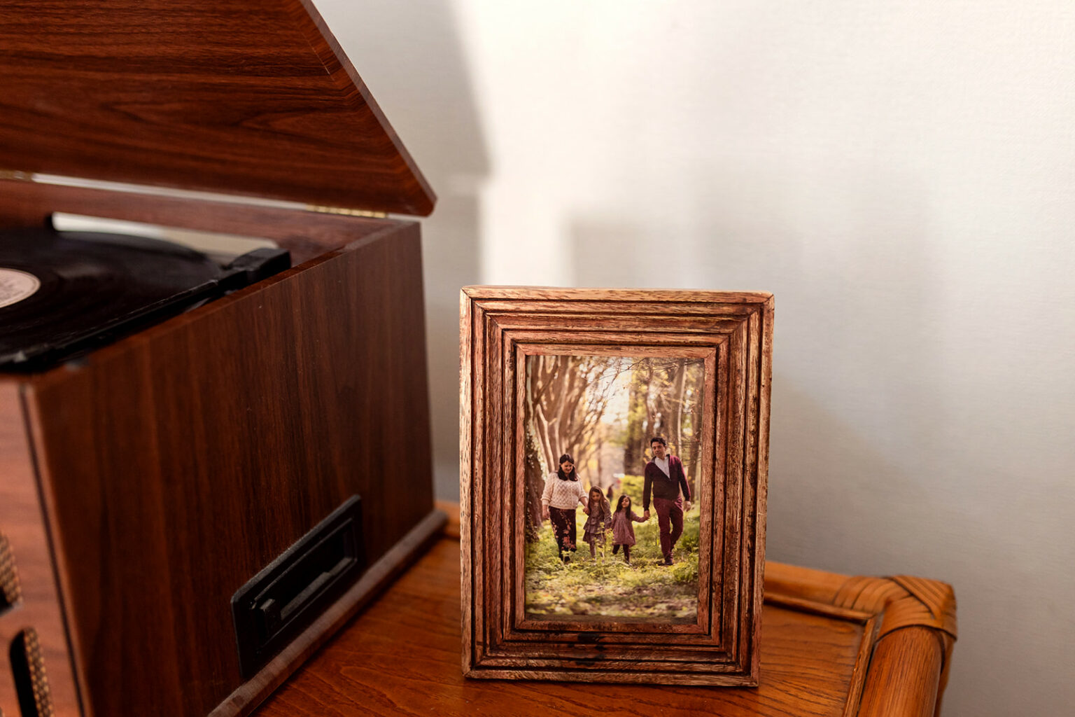 Framed photograph of a family walking in the woods, displayed beside a record player