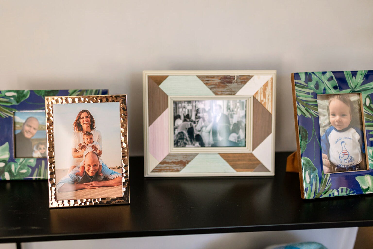 Framed family portraits displayed together on a shelf