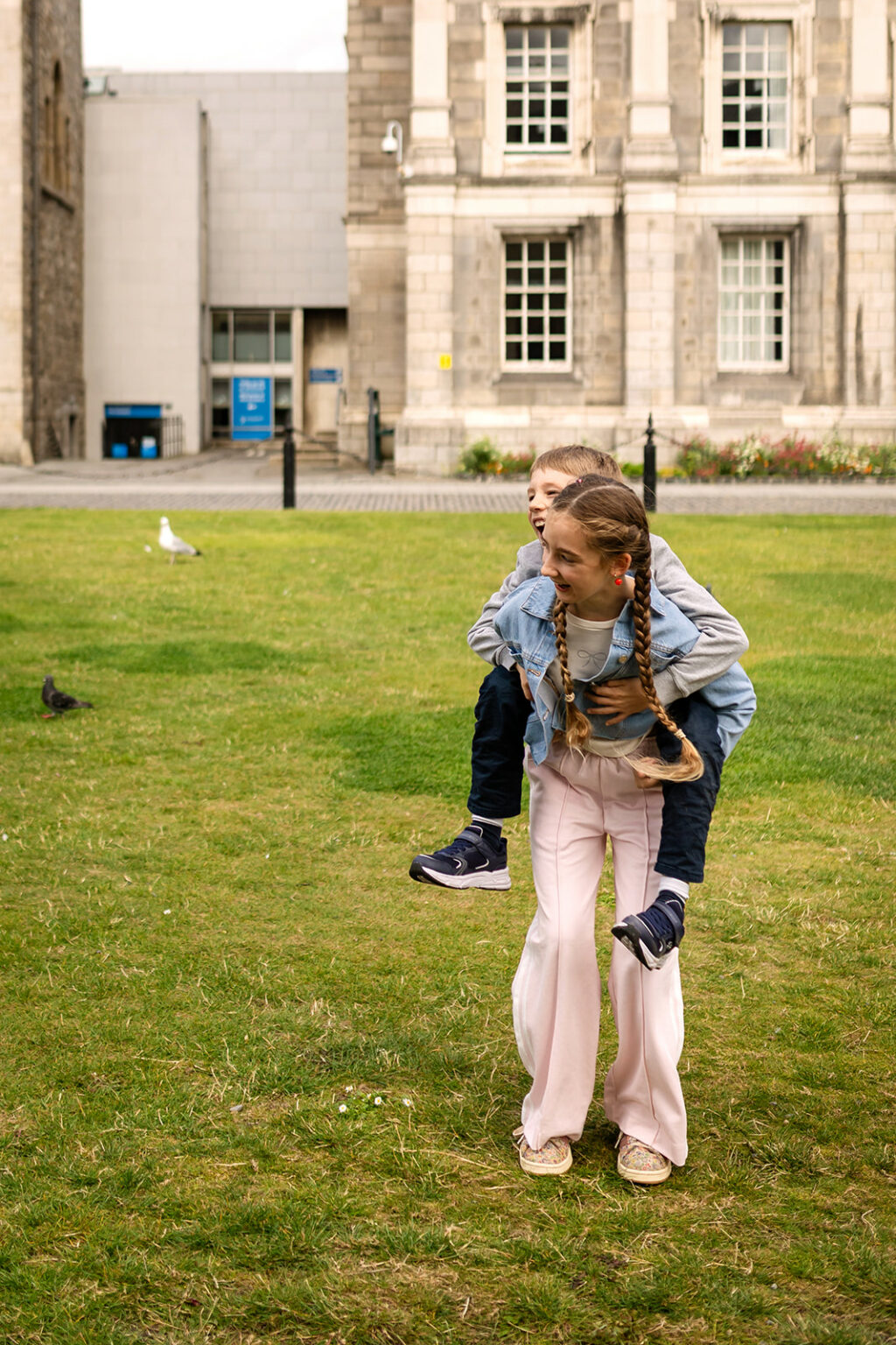 Children playing piggyback on the lawn at Trinity College Dublin